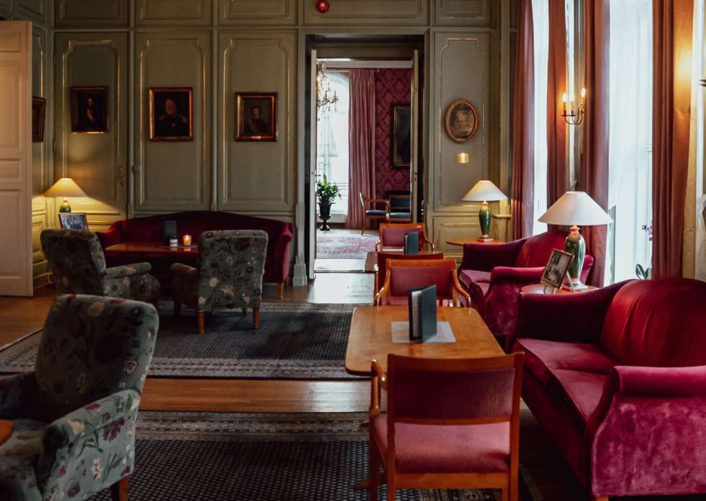 En lun og koselig innredet salong med sofaer og komfortable stoler i velur.